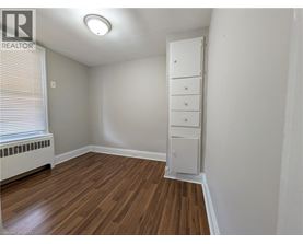 A room with a wooden floor and a white cabinet.