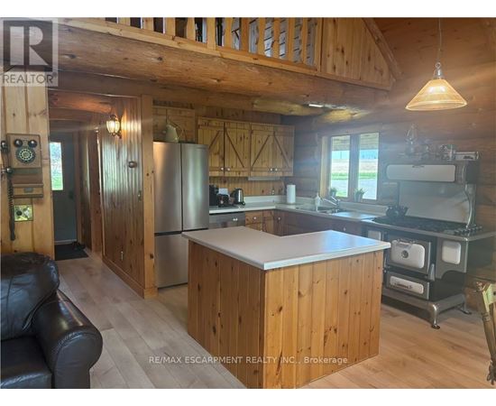 A kitchen with wooden cabinets and a stainless steel refrigerator.