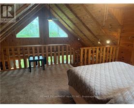 A bedroom with a bed and a window in a house under construction.
