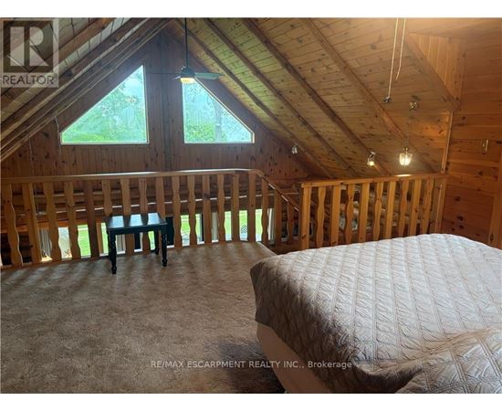 A bedroom with a bed and a window in a house under construction.