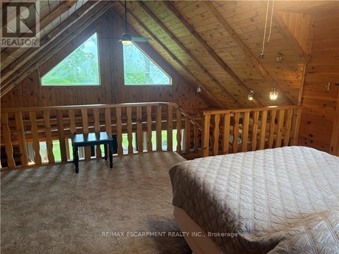 A bedroom with a bed and a window in a house under construction.