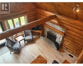 A cozy living room with a fireplace and a wooden ceiling.