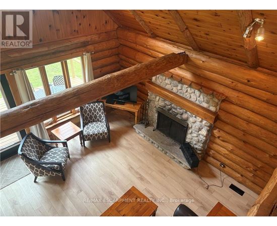 A cozy living room with a fireplace and a wooden ceiling.
