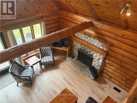 A cozy living room with a fireplace and a wooden ceiling.