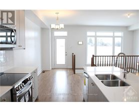 A modern kitchen with a stove top oven and a sink.