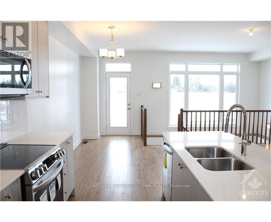 A modern kitchen with a stove top oven and a sink.
