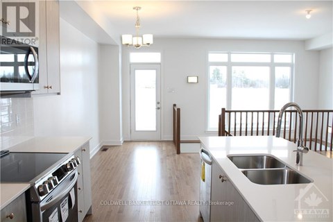 A modern kitchen with a stove top oven and a sink.