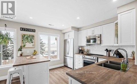 A kitchen with white cabinets and a wooden countertop.