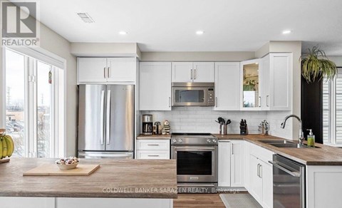 A modern kitchen with white cabinets and stainless steel appliances.