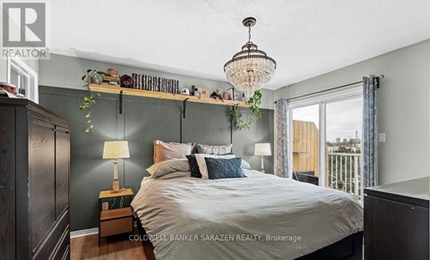 A bedroom with a large bed and a chandelier.