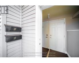 A white door is in a room with a white wall and a mailbox.