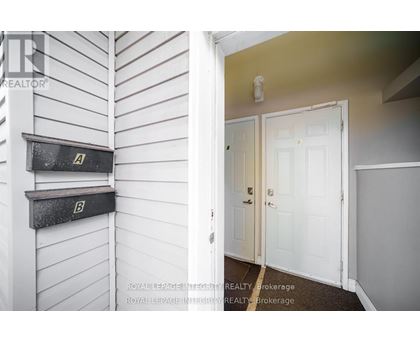 A white door is in a room with a white wall and a mailbox.