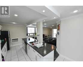 A kitchen with a black counter top and white cabinets.