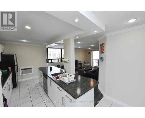 A kitchen with a black counter top and white cabinets.