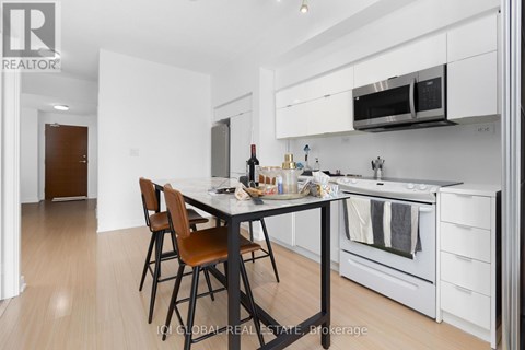 A kitchen with white cabinets and a black table.