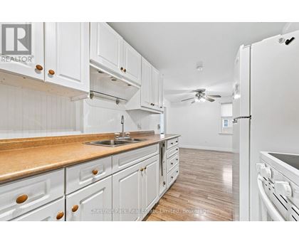 A kitchen with white cabinets and a wooden countertop.