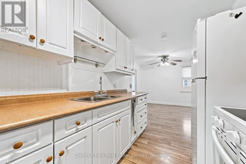 A kitchen with white cabinets and a wooden countertop.