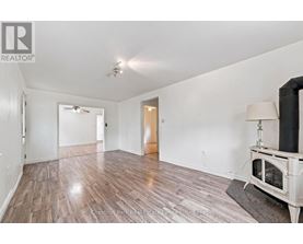 A spacious room with wood flooring and a fireplace.