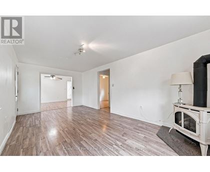 A spacious room with wood flooring and a fireplace.