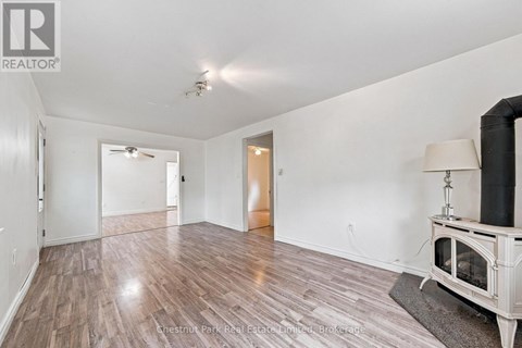 A spacious room with wood flooring and a fireplace.