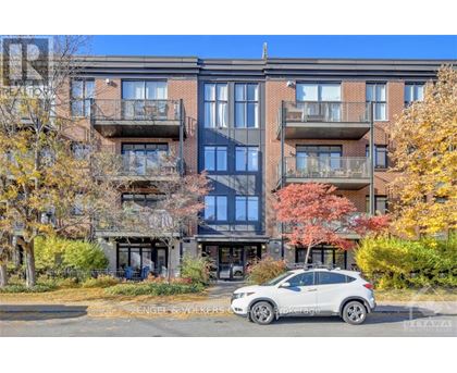 A modern apartment building with a car parked in front.