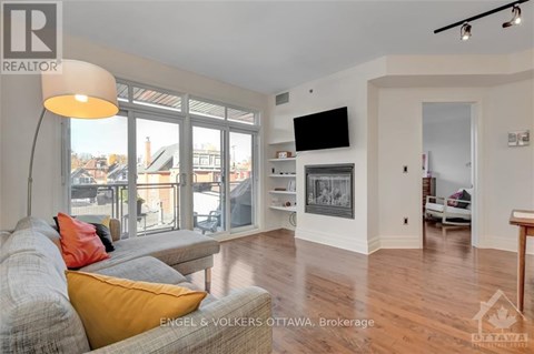 A living room with a grey couch and a yellow pillow.