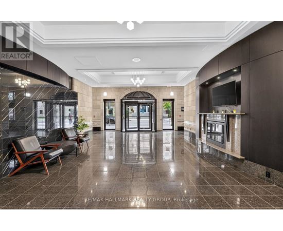A lobby with a marble floor and a large glass wall.