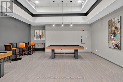 A room with a pool table and chairs.