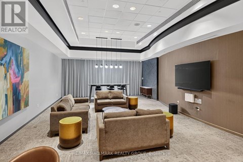 A living room with a large painting on the wall and a flat screen TV mounted on the wall.