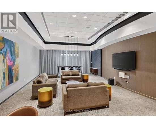 A living room with a large painting on the wall and a flat screen TV mounted on the wall.
