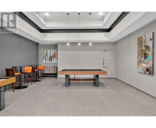 A room with a pool table and chairs.