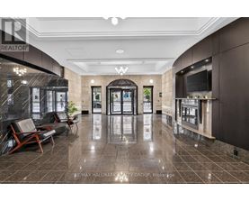A lobby with a marble floor and a large glass wall.
