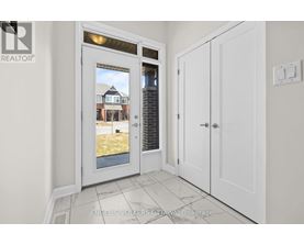 A white door with a window showing a house in the background.