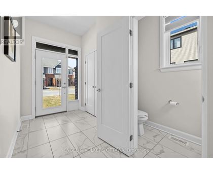A white bathroom with a toilet, sink, and a window.