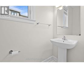 A white sink in a bathroom with a window above it.