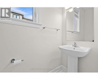 A white sink in a bathroom with a window above it.