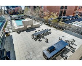 A rooftop patio with a pool and seating area.
