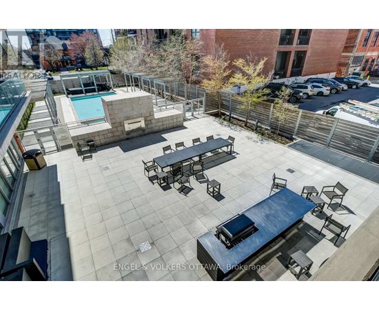 A rooftop patio with a pool and seating area.