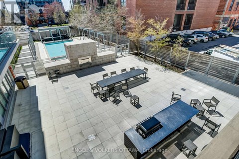 A rooftop patio with a pool and seating area.