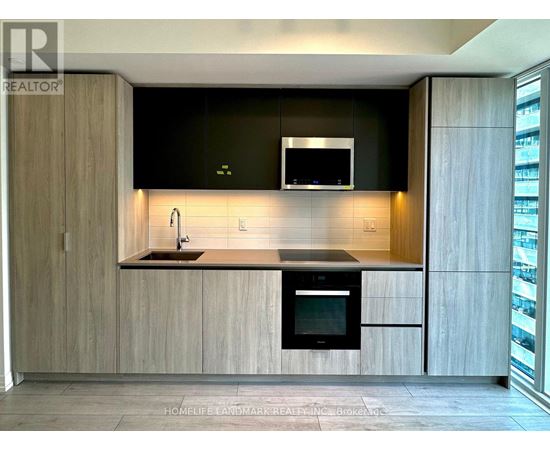 A modern kitchen with wooden cabinets and a black countertop.