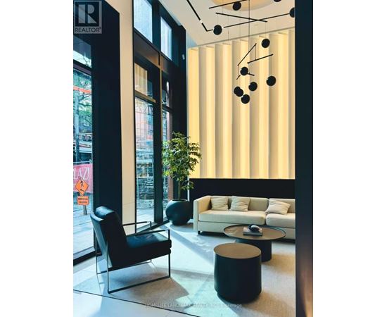 A black chair sits in front of a window in a modern living room.
