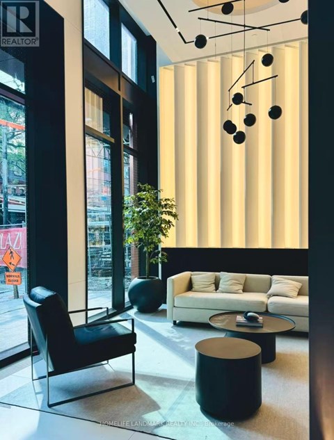 A black chair sits in front of a window in a modern living room.