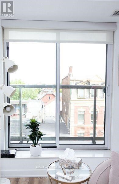A white table with a plant on it sits in front of a window.