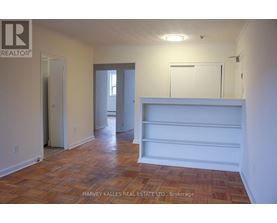 A room with wooden flooring and white walls.
