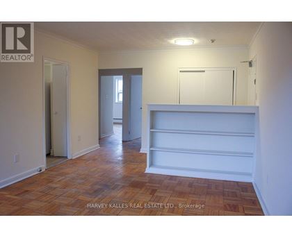 A room with wooden flooring and white walls.