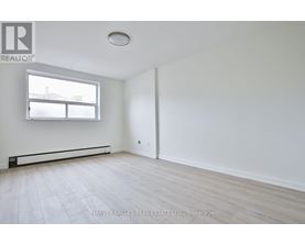 A spacious room with a window and a door.