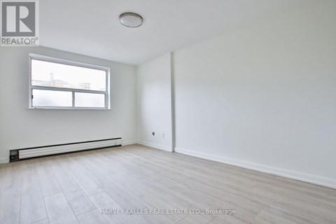 A spacious room with a window and a door.