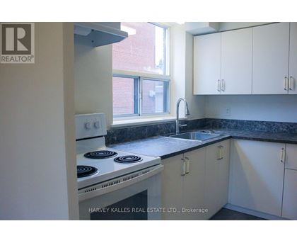A kitchen with white cabinets and a black countertop.