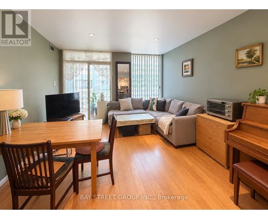 A living room with a grey couch and wooden furniture.