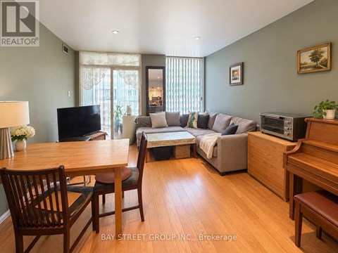 A living room with a grey couch and wooden furniture.